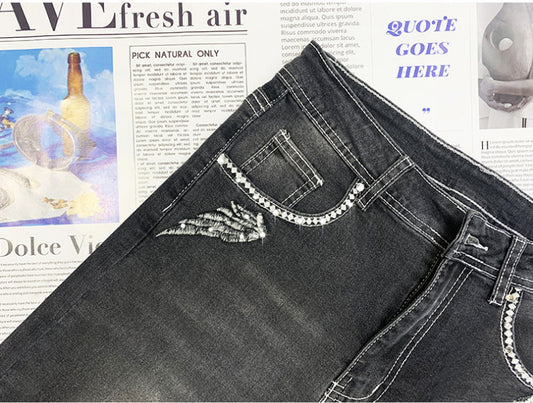 Pantaloni in denim aderenti elasticizzati con teschio ricamato retrò e strass caldi